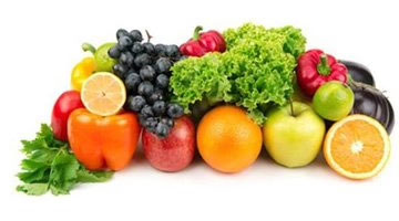 a pile of fruits and vegetables including grapes, peppers, oranges, apples, greens, and spinnach