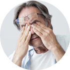 older man rubbing his eyes with both hands